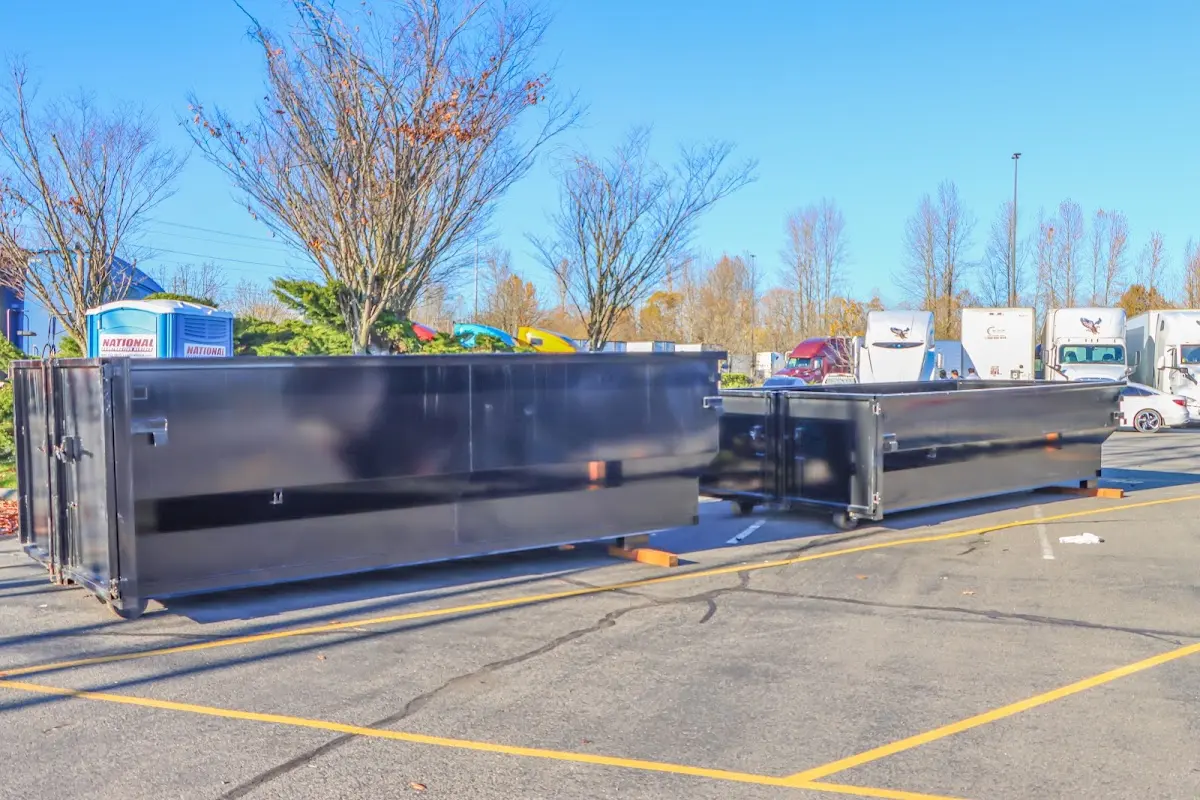 Professional dumpster rental service with roll-off container on residential driveway in Manalapan